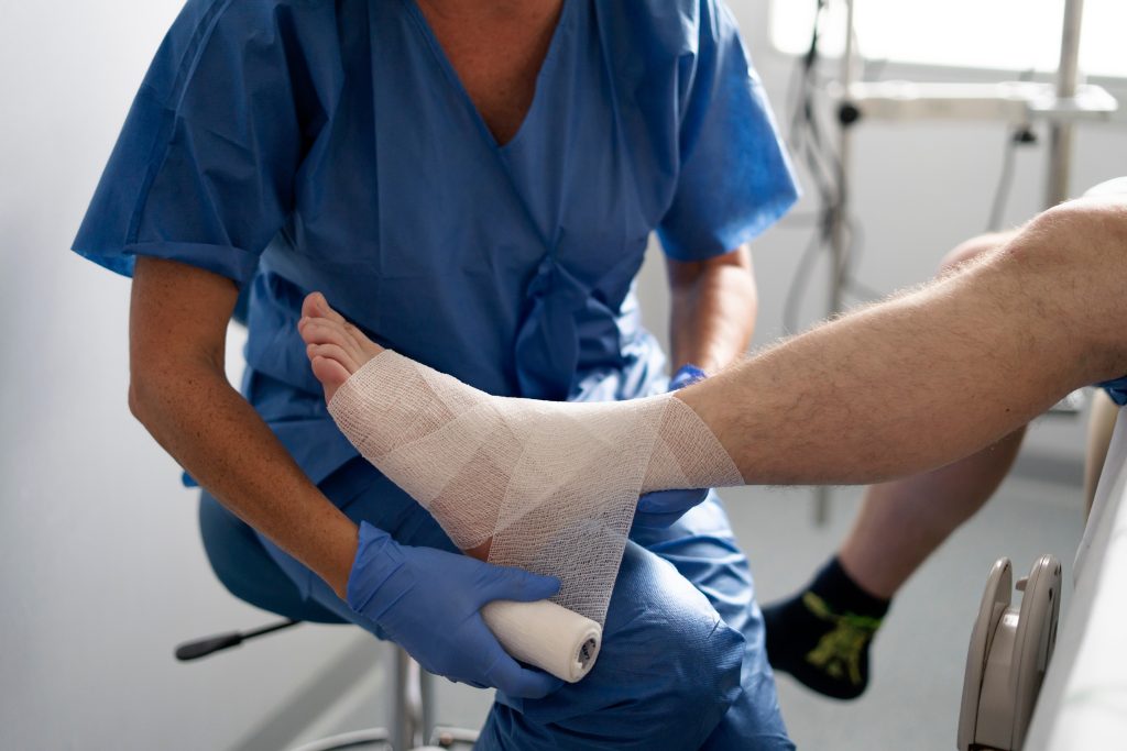 Medical,Professional,Carefully,Applying,Bandage,To,Patient's,Sprained,Ankle,,Providing